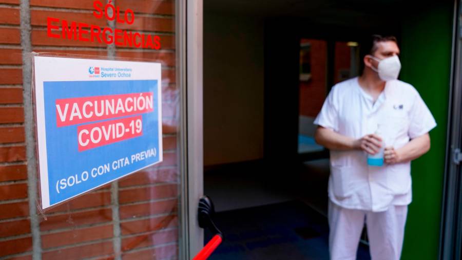 Un empleado sanitario al lado de una señal del dispositivo de vacunación puesto en marcha para inocular la primera dosis de la vacuna de Pfizer-BioNTech contra el Covid-19, a 9 de junio de 2021, en el Hospital Severo Ochoa de Leganés, Leganés, Madrid, (España) / A. Pérez Meca / Europa Press 09/06/2021