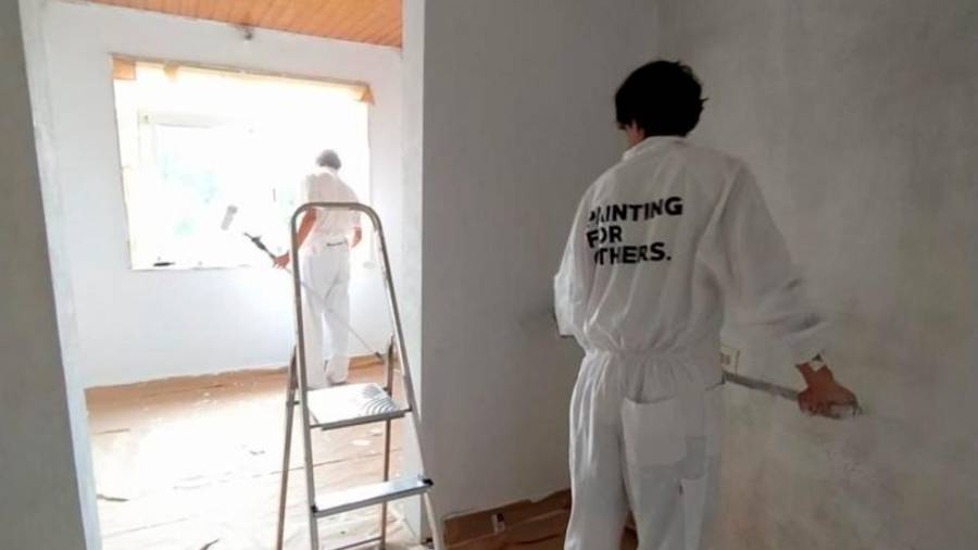 Dous voluntarios da iniciativa solidaria ‘Paiting for others’ pintando as paredes. Foto: C.A.