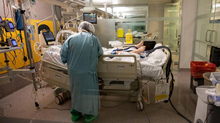 Sanitario que trabaja en la unidad de Reanimación del hospital Clínico de Santiago con un paciente COVID Foto: A. Varela