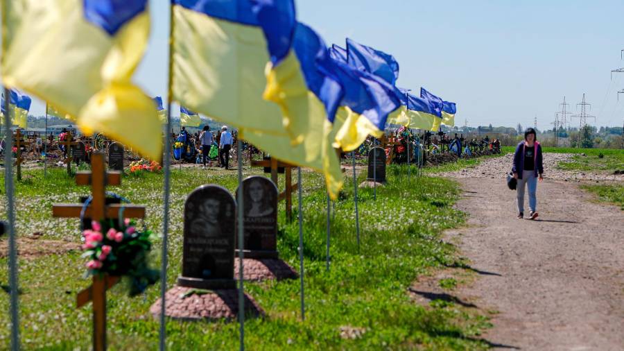 12 de mayo de 2022, Dnipro, Dnipro, Ucrania: Esposa del soldado ucraniano fallecido Víctor, que fue asesinado a los 40 años, camina por la carretera bordeada de banderas ucranianas después de rendir homenaje a su marido, en una fosa común para soldados ucranianos en Dnipro, en medio de la invasión rusa de Ucrania. FOTO: Daniel Ceng Shou-Yi / Zuma Press / ContactoPhoto / 05/12/2022