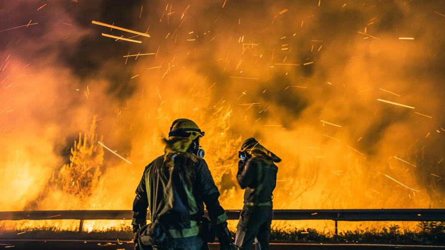 Miembros de las brigadas desesperados ante el voraz avance de las llamas. Foto: Óscar Corral / Efe