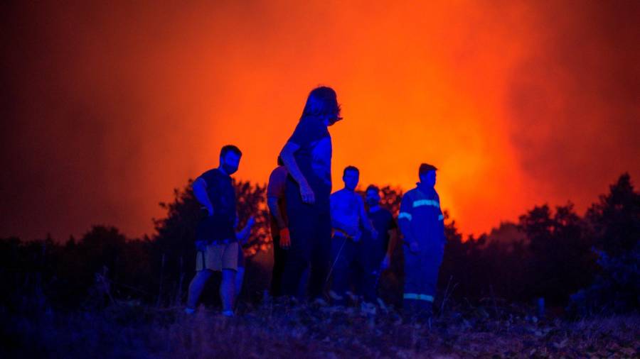 GRAF4334. RAIRIZ DE VEIGA (OURENSE), 13/09/2020.- Vecinos de Cualedro observan el avance de el incendio forestal de Cualedro (Ourense), que ha obligado a decretar la situación 2 por la proximidad a las viviendas. Galicia ha vivido un fin de semana negro, recrudecido este domingo, con más de 2.250 hectáreas forestales arrasadas por el fuego en tres provincias, la de Ourense, que se ha llevado la peor parte con nueve incendios; la de Lugo y la de Pontevedra. EFE/ Brais Lorenzo