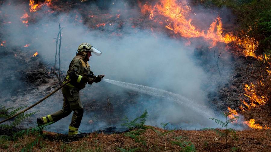 GRAF9828. TOÉN (OURENSE), 07/08/2020.- Un bombero realiza labores de extinción en el incendio forestal que permanece activo en el municipio orensano de Toén. EFE/Brais Lorenzo
