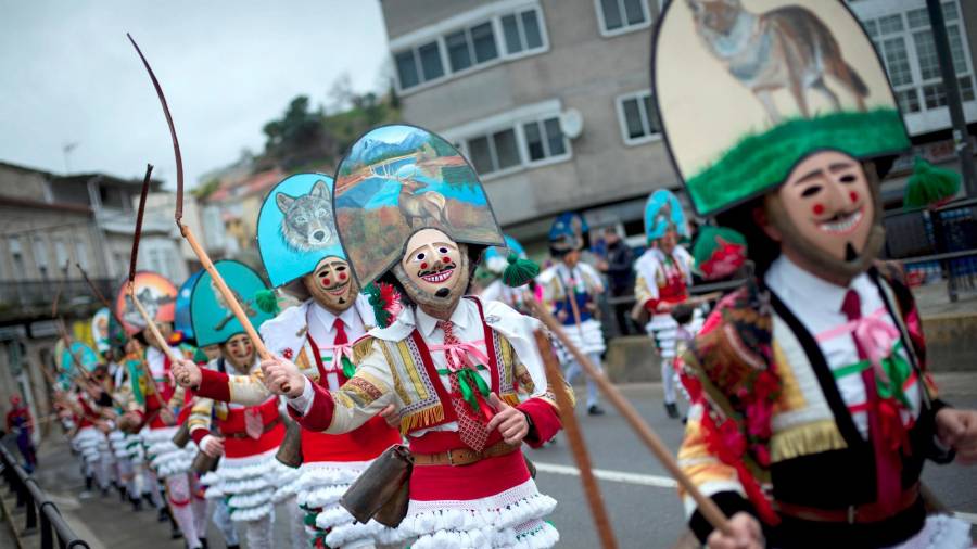 Un grupo de Cigarróns, uno de los personajes más representativos del Carnaval gallego, desfila, haciendo sonar sus chocas, por las calles de Verín. (Autor, Brais Lorenzo. Fuente, EFE)