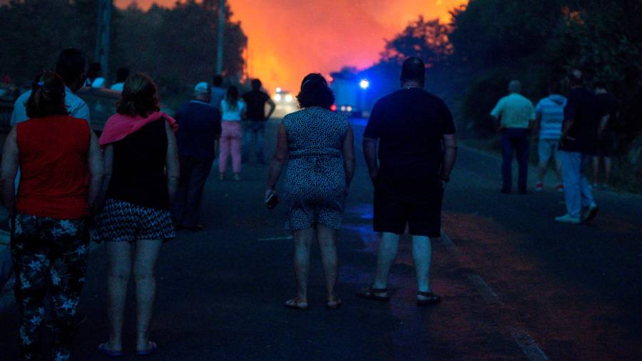 GRAF4334. RAIRIZ DE VEIGA (OURENSE), 13/09/2020.- Vecinos de Cualedro observan el avance de el incendio forestal de Cualedro (Ourense), que ha obligado a decretar la situación 2 por la proximidad a las viviendas. Galicia ha vivido un fin de semana negro, recrudecido este domingo, con más de 2.250 hectáreas forestales arrasadas por el fuego en tres provincias, la de Ourense, que se ha llevado la peor parte con nueve incendios; la de Lugo y la de Pontevedra. EFE/ Brais Lorenzo