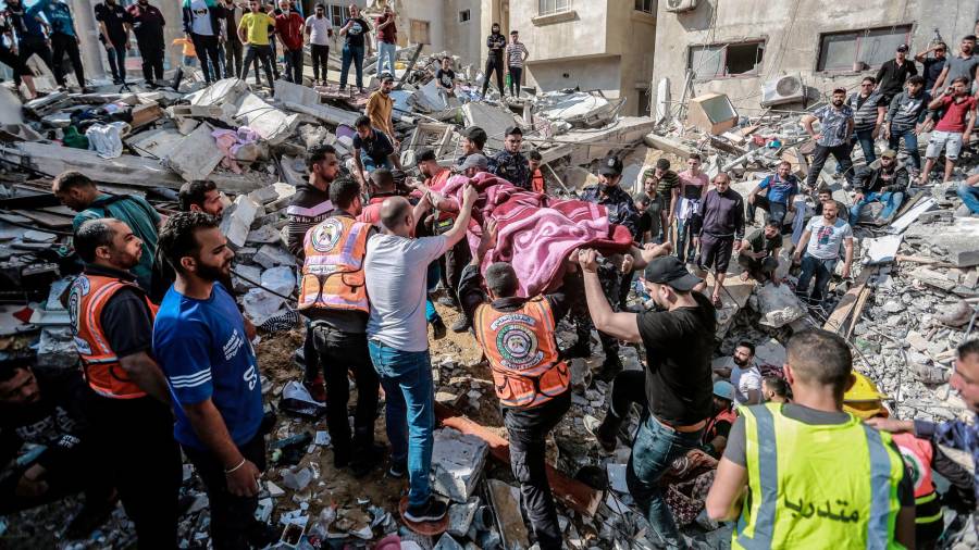 16 de maio de 2021, territorios palestinos, cidade de Gaza: os paramédicos palestinos desenterran o corpo dunha persoa morta atopada nos cascallos dunha casa derrubada tras un ataque aéreo israelí, no medio do intenso estalido da violencia israelí-palestina. Foto: Mohammed Talatene / dpa