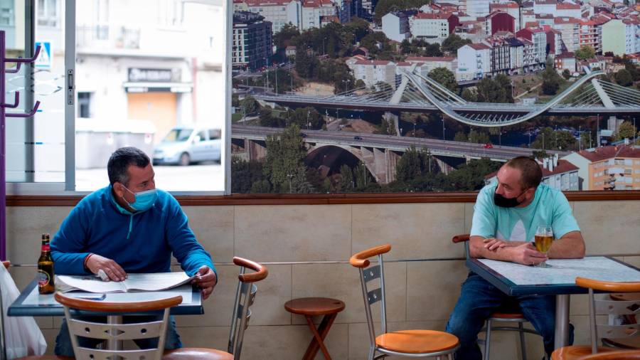 juntos pero no revueltos. Dos clientes de un bar de Ourense toman algo en mesas separadas aunque estén charlando juntos. En la ciudad están prohibidas las reuniones de personas no convivientes. Foto: B. Lorenzo 