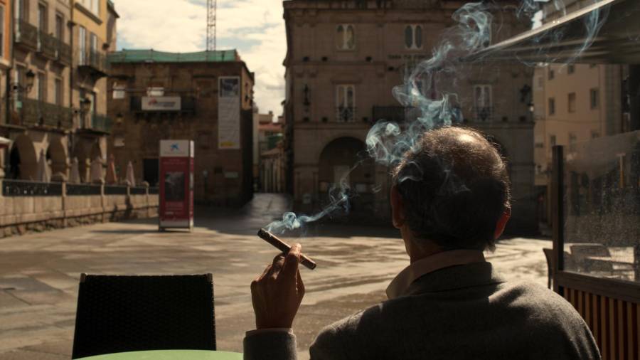 covid-19. Un hombre fuma sentado en una terraza en la Plaza Mayor de Ourense. Foto: Efe