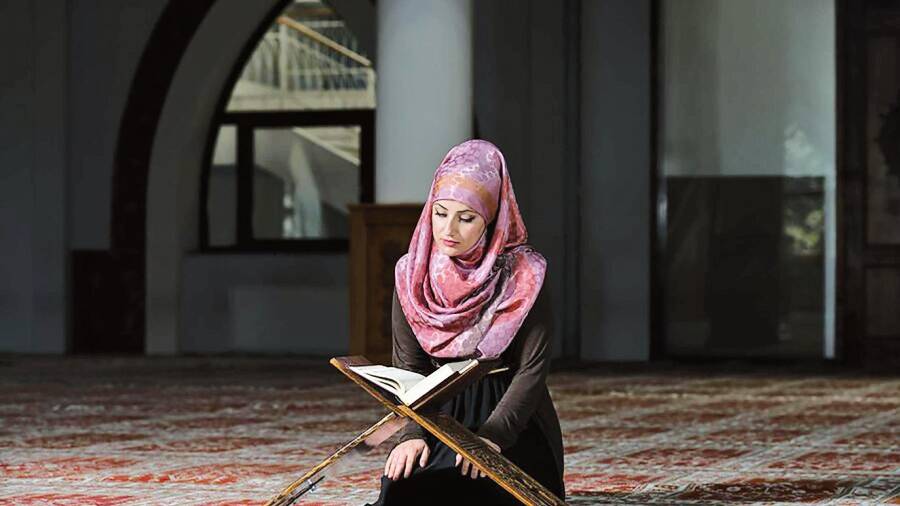 Mujer leyendo el Corán, libro sagrado de los musulmanes que contiene las revelaciones que Dios hizo a Mahoma.
