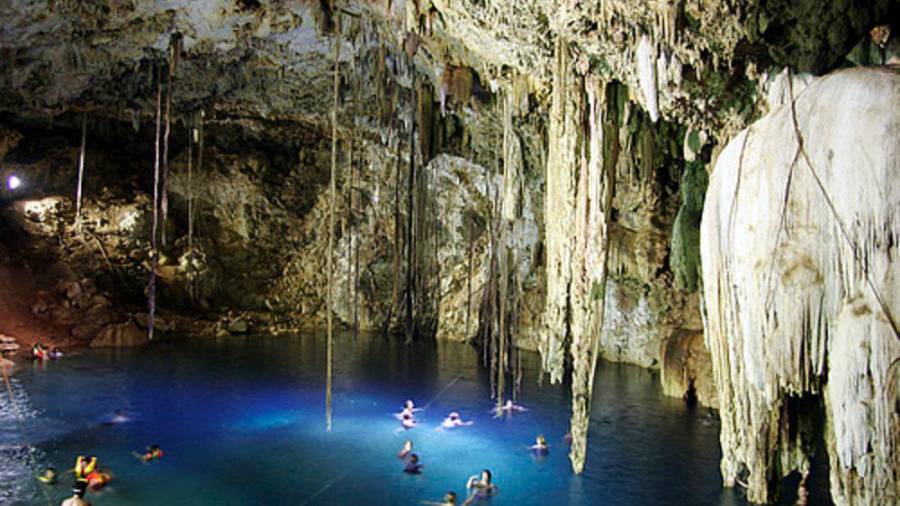 Cenote Dzitnup. Esta maravilla de la naturaleza es uno de los más bellos cenotes de Yucatán, México. Lo llaman La cueva azul por la transparencia de sus aguas que se iluminan con los escasos rayos de sol que penetran en través del orificio de la cúpula. La caverna subterránea tiene un gran lago de aguas prístinas rodeado de un singular decorado de estalactitas y estalagmitas que se reflejan en el agua. (Fuente, www.nationalgeographic.com)