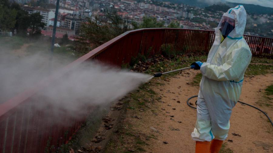 OURENSE, 23/10/2020.- Un operario municipal realiza labores de desinfección a primera hora de este viernes en la ciudad de Ourense. EFE/ Brais Lorenzo