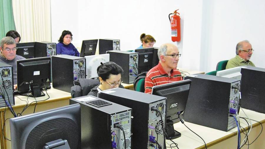 Usuarios en los ordenadores que tiene el Aula CeMIT en la primera planta de la casa de la cultura de Bertamiráns. Foto: CA