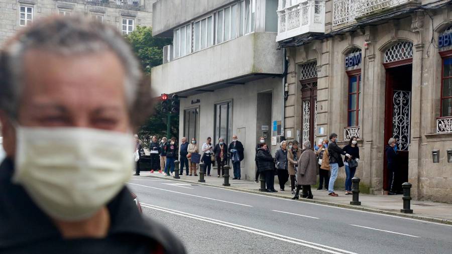 Personas esperando a acceder a una oficina del BBVA en Compostela. FOTO: ANTONIO HERNÁNDEZ
