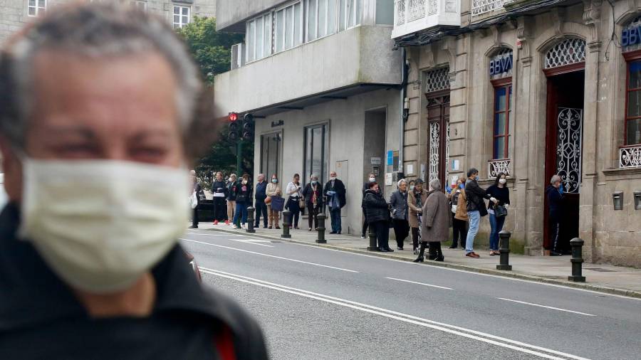 Colas a las puertas de una entidad bancaria de Santiago el lunes 4 de mayo. Muchas de las personas acudían para cobrar los ERTE. FOTO: ANTONIO HERNÁNDEZ