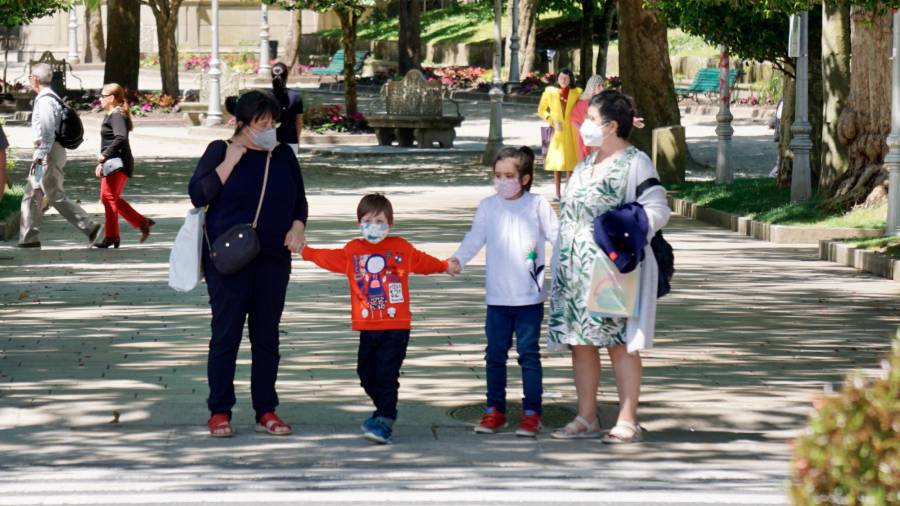 Cae la natalidad y aumentan los mayores de 65 años en Galicia. En la imagen, una familia con dos menores paseando por la Alameda compostelana