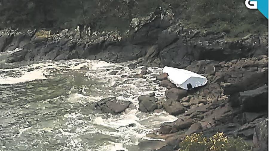 TEMPORAL. Los restos de la planeadora blanca varados en las rocas en cabo Corcubión