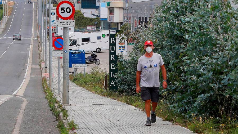 LUGO, 11/07/2020.- Un hombre camina por el polígono de Burela en Lugo, este sábado, un día antes de las elecciones regionales, mientras continúa el confinamiento de la localidad debido a un brote de coronavirus. EFE/ Eliseo Trigo