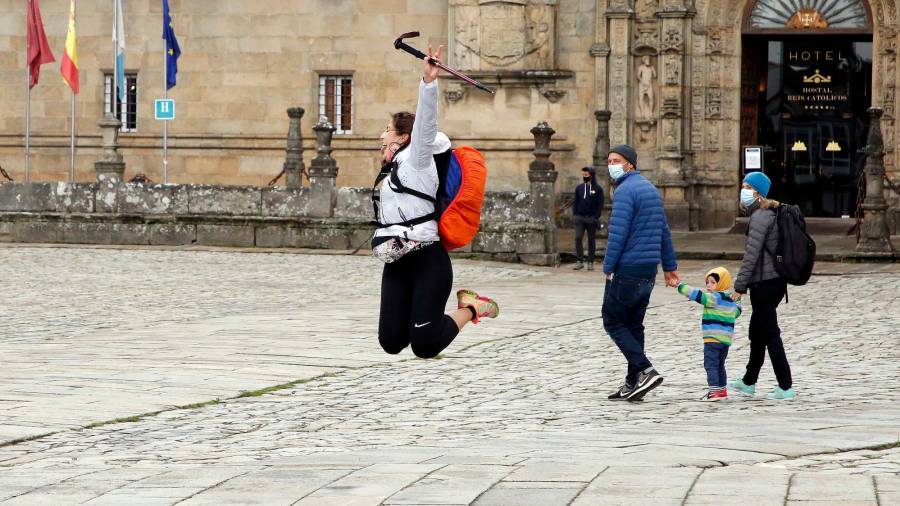 SANTIAGO. Una peregrina celebracon un salto en la Praza do Obradoiro la llegada a Compostela ante la mirada de más visitantes. Foto: Antonio Hernández