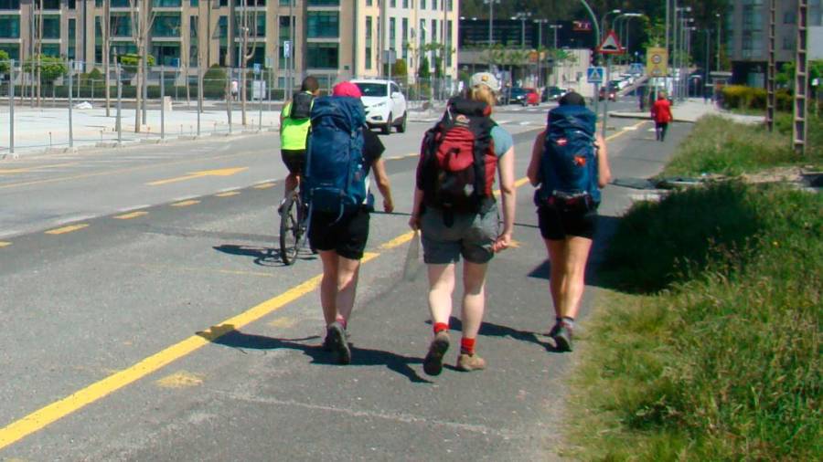 Tres peregrinos a su paso por la Travesía do Porto de O Milladoiro, Ames. Foto: CG