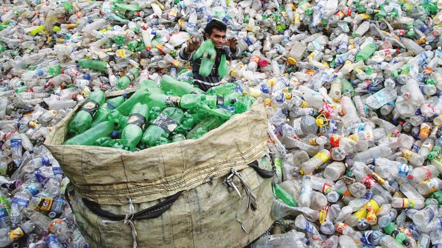 Un hombre recupera botellas de plástico en un vertedero de Chandigarh, India.