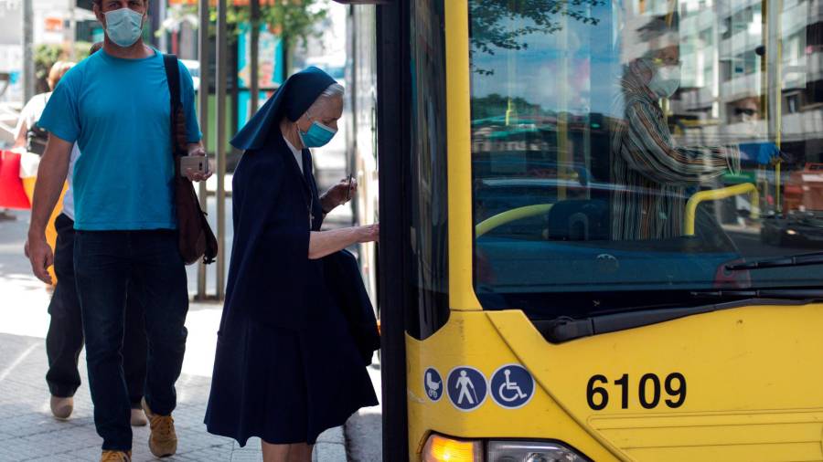 Una monja protegida con mascarilla se sube a un autobús urbano en la ciudad de Ourense. Foto: Brais Lorenzo