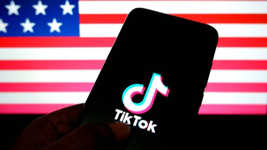 Logotipo de TikTok sobre un fondo con la bandera de Estados Unidos. FOTO: AVISHEK DAS