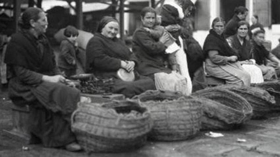 Mujeres en el mercado con sus cestas llenas de productos, en la praza de San Fiz de Solovio. Foto: R. M. Anderson