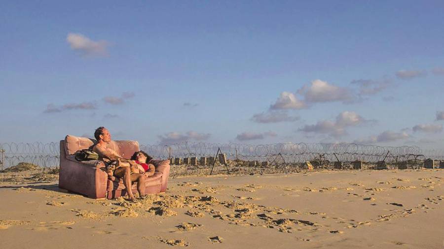 Una pareja israelí descansa en la playa de Kibbutz Zikim, en la frontera de Israel con Gaza.