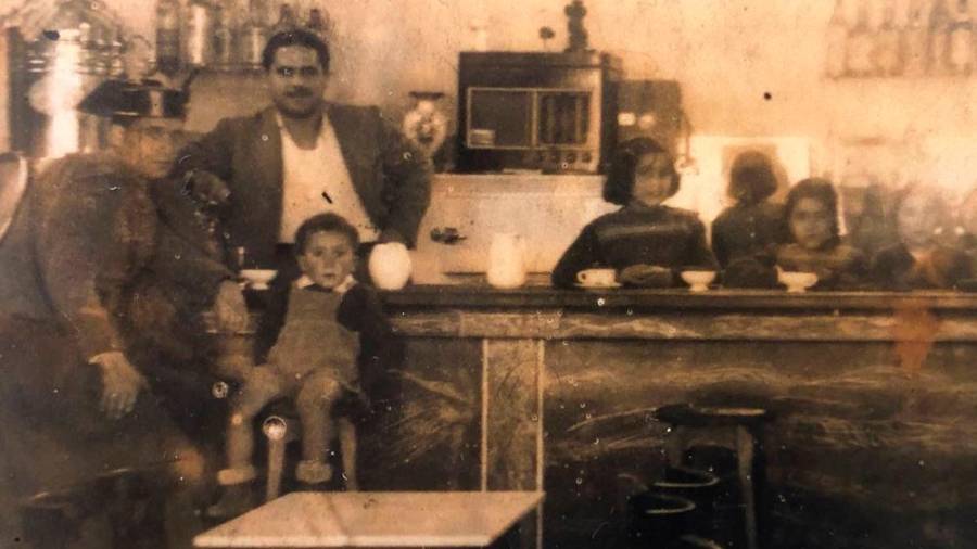 el TOCADISCOS. Feliciano Rial, fundador del emblemático bar, tras la barra, junto a sus hijas Pilar, Margarita y Carlota; tras ellos, el tocadiscos que puso en el balcón para estrenar la Rianxeira en el año 1949. Foto: B.F.