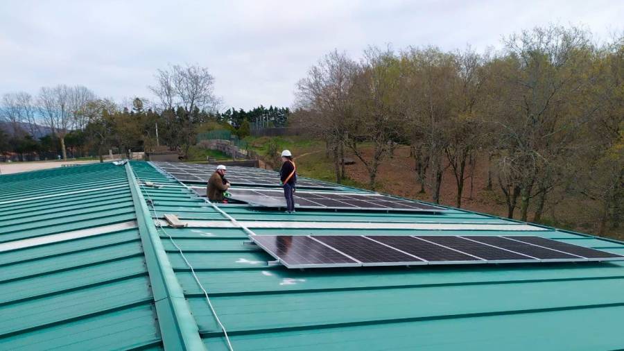 recursos limpios. Dos instaladores ensamblan diversas placas fotovoltaicas de un montaje de autoconsumo (Galicia). Foto: Ecoloxistas en Acción 