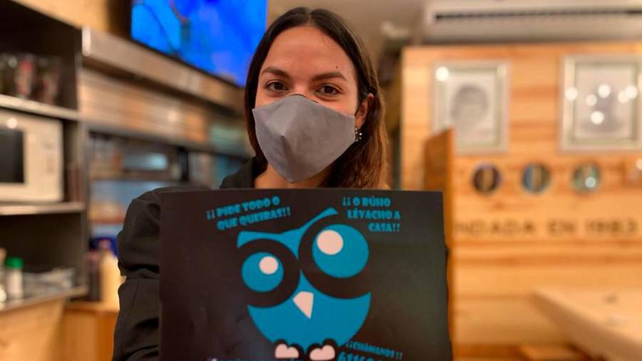 A xoven emprendedora Sandra Vargas sostendo un cartel informativo de “O Búho”. Foto: cedida