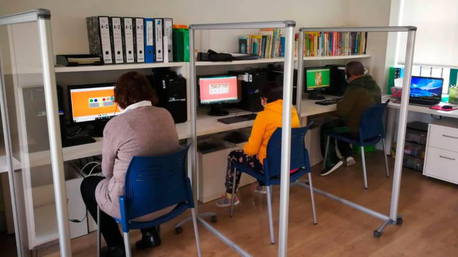Usuarios de Aspamite realizando tareas en los ordenadores, separados por mamparas. Foto: Aspamite.