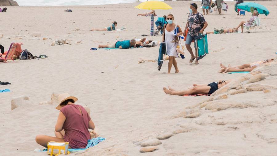 NORMA OBLIGATORIA Un par de personas llegan a una playa con la mascarilla puesta (Foto: Paula Amati)