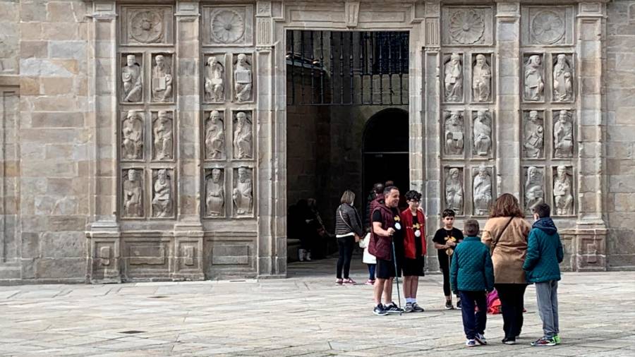 Una familia posa esta mañana, con indumentaria peregrina, a su llegada a la Puerta Santa de la Catedral. Foto. A.R.
