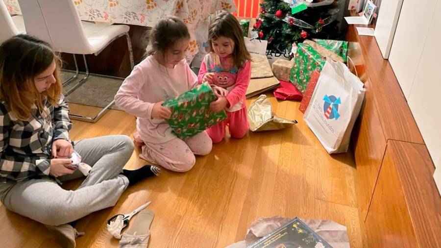 Andrea observa como Julia y Carla, las pequeñas de la casa, desenvuelven uno de los regalos. Detrás, todavía muchos paquetes esperan bajo el árbol. Fotos: ECG