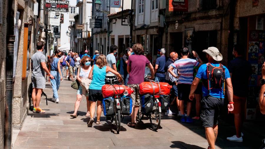 Varios peregrinos caminan con su bicicleta por la Rua do Franco, el día en que el TSXG declara nula la petición de certificado Covid para entrar en hostelería, a 12 de agosto de 2021, en Santiago de Compostela, A Coruña, Galicia (España) // César Arxina / Europa Press (Foto de ARCHIVO) 12/08/2020
