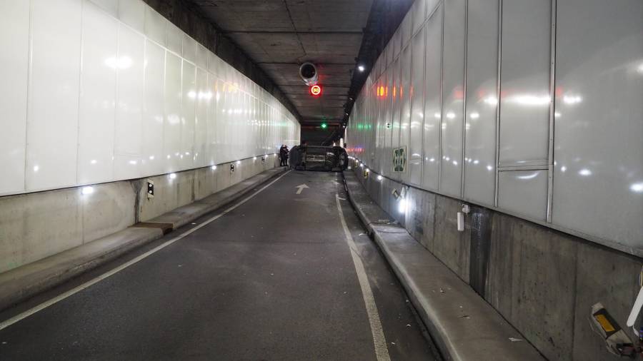 Al fondo, imagen del vehículo que volcó la madrugada de este miércoles en el túnel de María Pita, en A Coruña. FOTO: POLICÍA LOCAL DE A CORUÑA