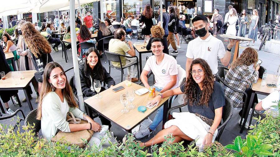 pocas barras. Un grupo de jóvenes en una cafetería de Santiago, donde la mayoría de los locales optaron por seguir con los mostradores cerrados a los clientes . Foto: F. Blanco