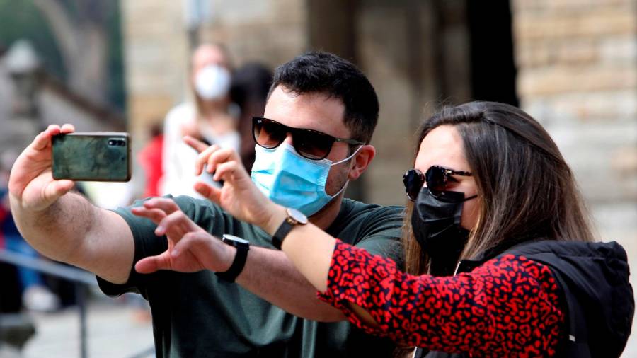 Ganas de disfrutar. Dos turistas se hacen un selfi en la compostelana Praza do Obradoiro Foto: Efe