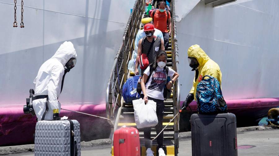 Cebu (Filipinas), 23/05/2020.- Trabajadores del gobierno filipino desinfectan equipajes de viajeros al pie de un avión. EFE/EPA/JAY ROMMEL LABRA