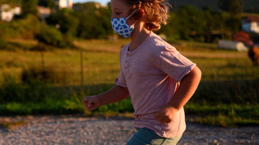 nueva normalidad. Un niño con mascarilla jugando este martes en Suances. Foto: Efe