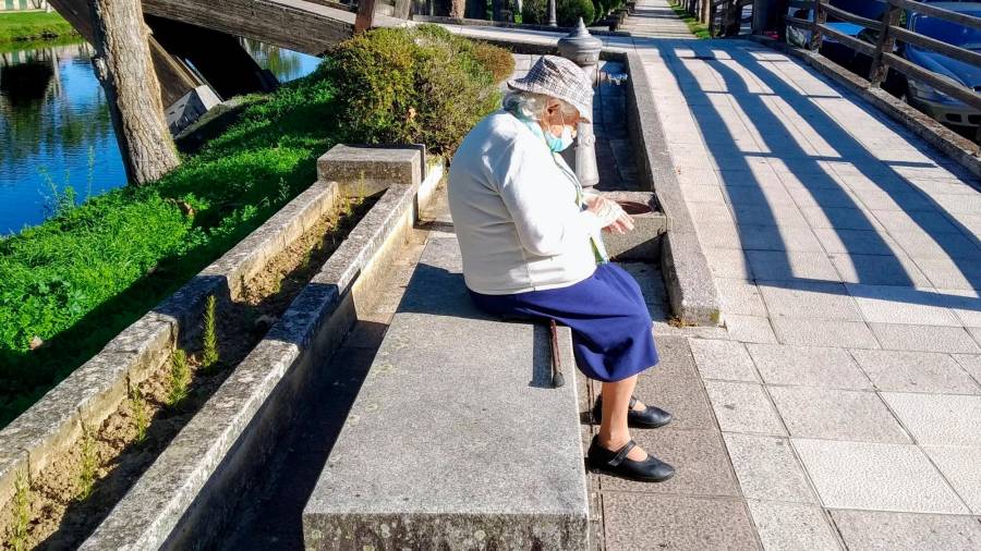 DEMOGRAFÍA. Una mujer mayor toma el sol en un banco de un paseo peatonal Foto: Angar