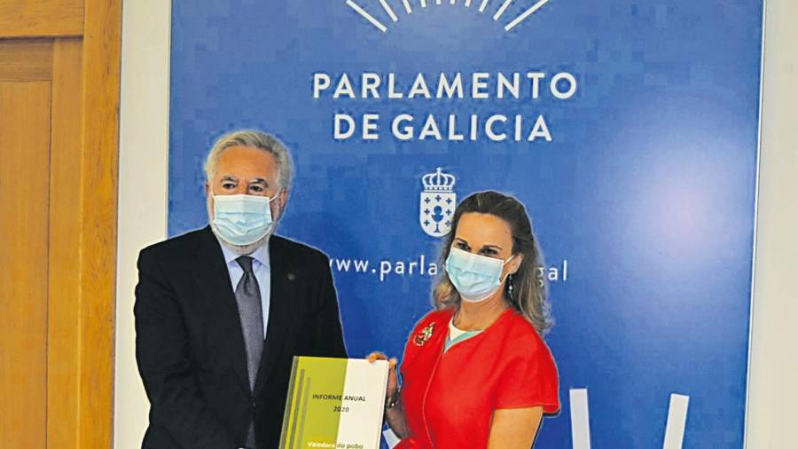 MÁS ACTIVIDAD. María Dolores Fernández Galiño entrega a Miguel Santalices el Informe Anual 2020 del Valedora do Pobo, con la actuación el pasado año. Foto: Parlamento