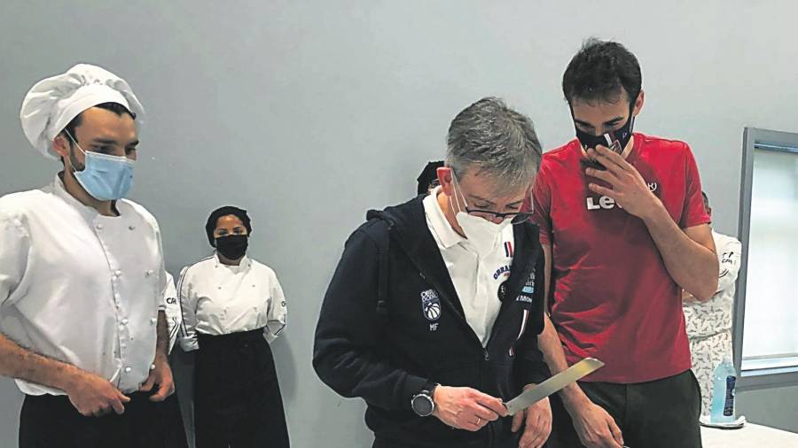 El técnico Moncho Fernández, cuchillo en mano, se dispone a cortar la tarta dedicada al Obradoiro