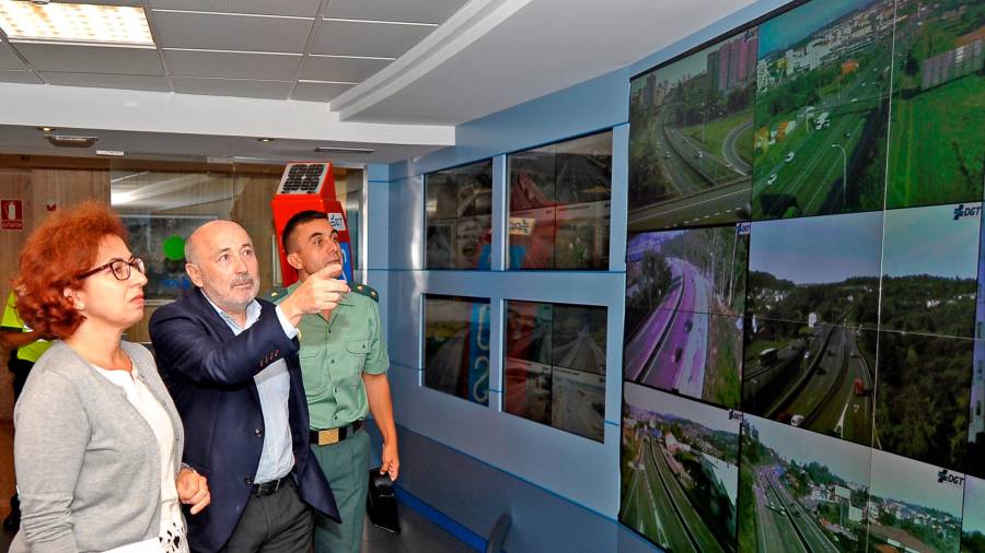 El delegado del Gobierno, entre los jefes de Tráfico, ante el muro visual de control del Centro de Gestión. Foto: Almara