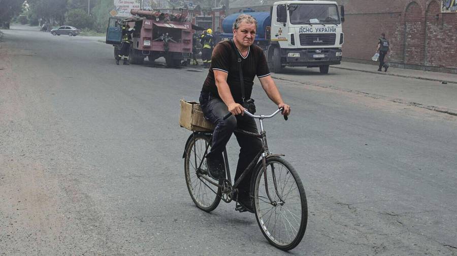 Un hombre conduce una bicicleta en una calle de Slóviansk después de un bombardeo. Foto: Marko Djurica