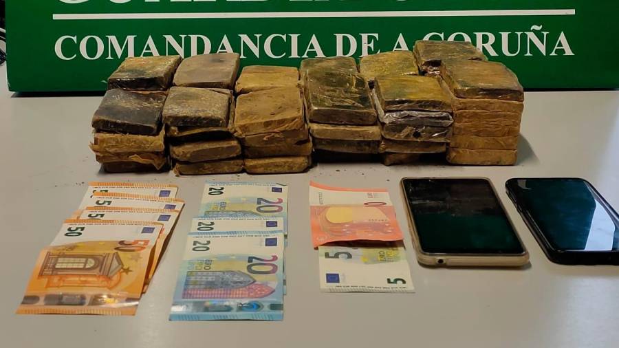 El hachís, el dinero en metálico y los teléfonos móviles intervenidos por la Guardia Civil en el municipio de Cee. Foto: G.C.