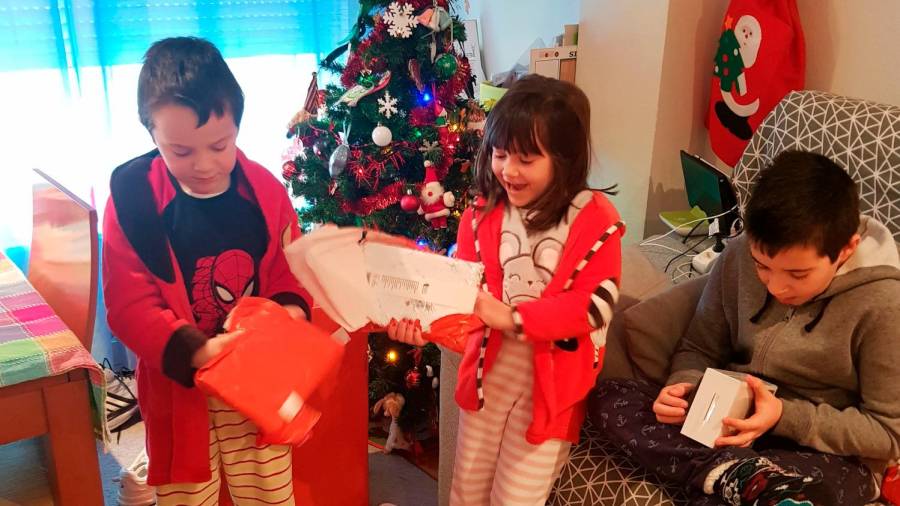 Ismael, Ana y Diego centrado cada uno en abrir sus respectivos regalos, con caras de sorpresa