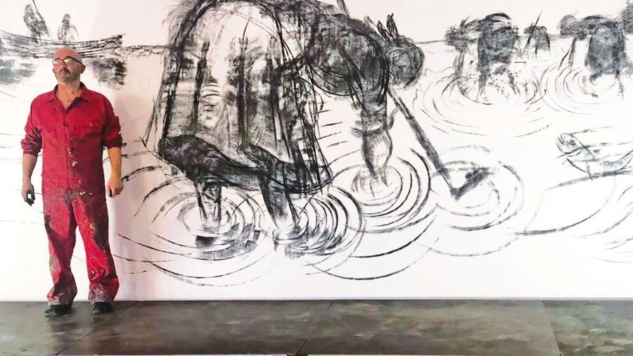 o mural. O artista Ramón Trigo ante o mural de catro metros que realizou en 2020 cando remataron as obras de construción do Museo do Mar de Noia e no que pintou unha escena de marisqueo. Foto: Suso Souto
