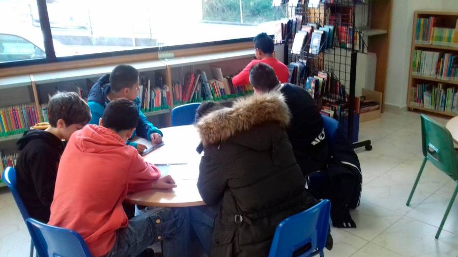Un grupo de rapaces amesáns elaborando un traballo na biblioteca do Milladoiro. Foto: CDA